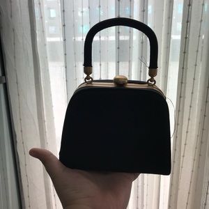 Small black fabric clutch with gold accents